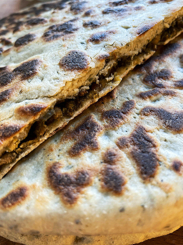 全帧图像的印度早餐菜，切成片的keema paratha，美味的大饼塞满了五香肉末，绞碎的牛肉或羊肉